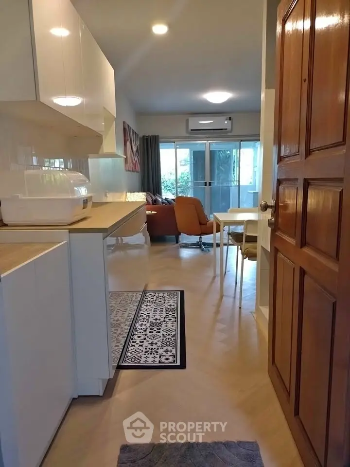 Charming open-layout living room with modern kitchen and cozy dining area, perfect for urban living.