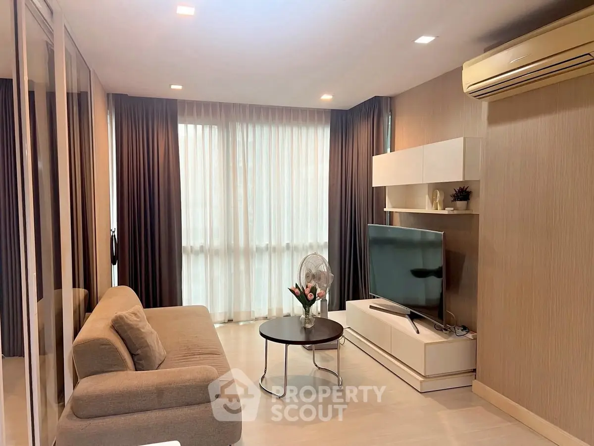 Modern living room with sleek furniture and large windows in a stylish apartment.