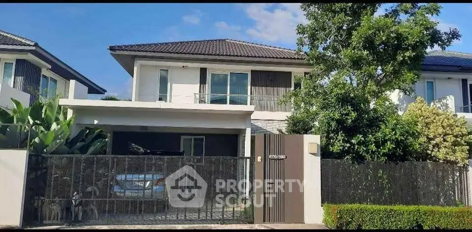 Charming two-story house with modern design and lush greenery, perfect for family living.