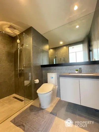 Modern bathroom with glass shower and sleek fixtures in luxury apartment