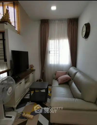 Cozy living room with modern decor, featuring a comfortable sofa, TV, and stylish geometric rug.