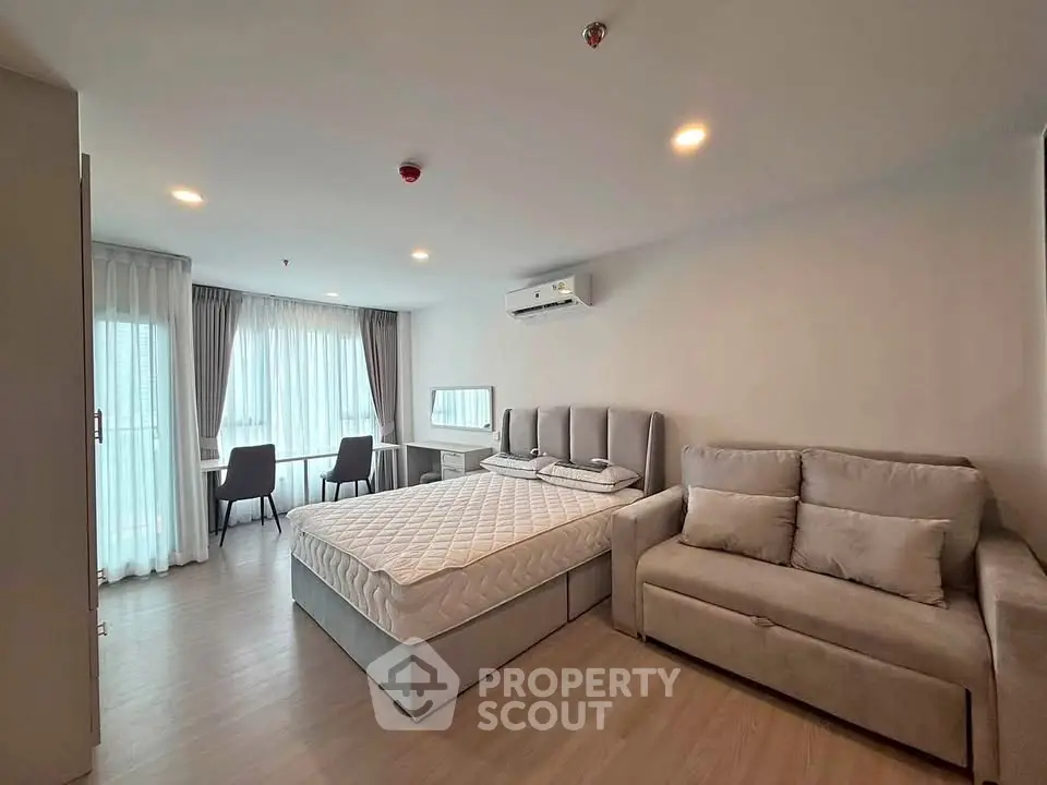 Modern bedroom with cozy sofa and natural light in a stylish apartment