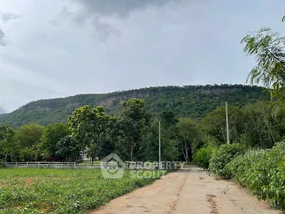 Scenic view of lush green landscape with mountain backdrop, ideal for serene living.