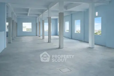 Spacious open-plan interior with large windows and concrete flooring, ideal for versatile commercial use.