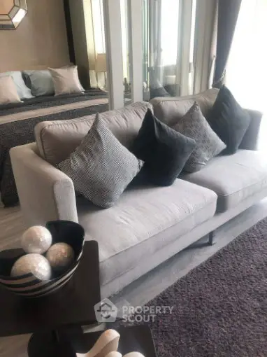 Stylish modern living room with cozy gray sofa and chic decor accents.