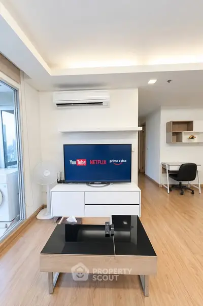 Modern living room with TV and workspace in stylish apartment