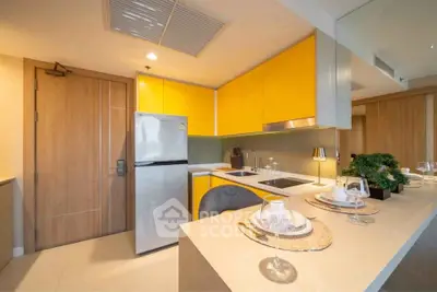 Modern kitchen with vibrant yellow cabinets and sleek appliances in a stylish apartment.