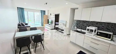Modern open-plan living room and kitchen with sleek design and natural light.