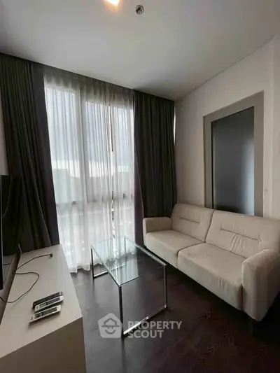 Modern living room with sleek furniture and large window, perfect for urban living.