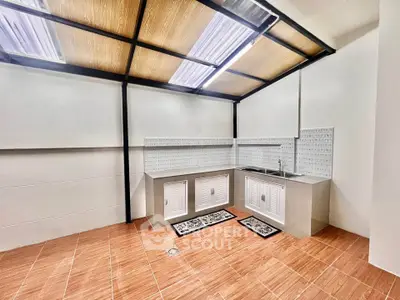 Modern kitchen with sleek design and ample storage space, featuring tiled flooring and contemporary lighting.