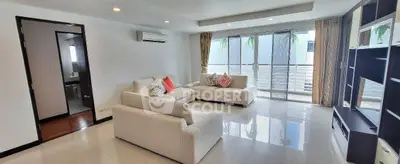 Spacious modern living room with large windows and elegant furniture in a bright apartment.