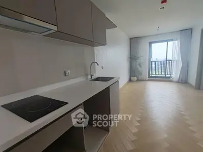 Modern open-layout kitchen with sleek cabinetry and balcony view