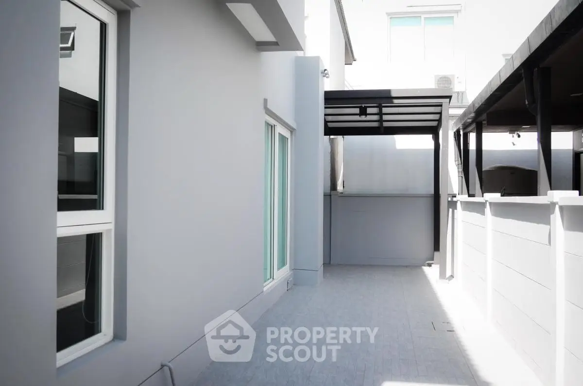 Modern exterior corridor with sleek design and large windows in a contemporary building.