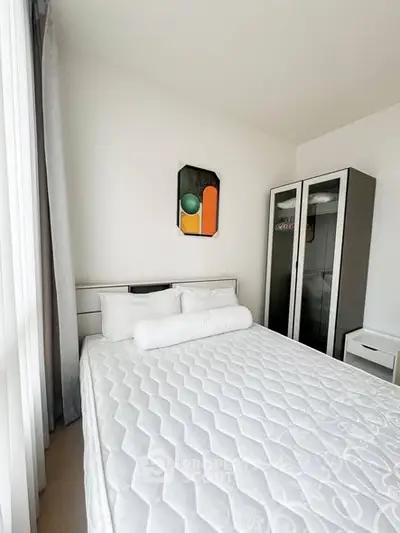 Modern bedroom with minimalist decor and large window for natural light.