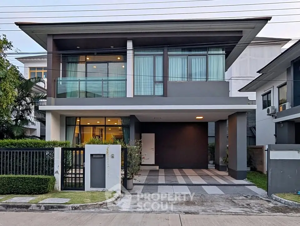 Modern two-story house with sleek design and large windows in a suburban neighborhood.