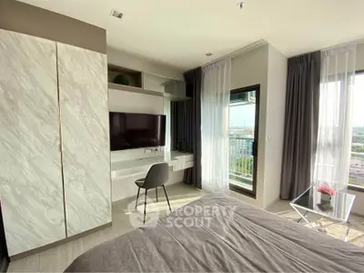 Modern bedroom with city view, featuring sleek furniture and large windows for natural light.