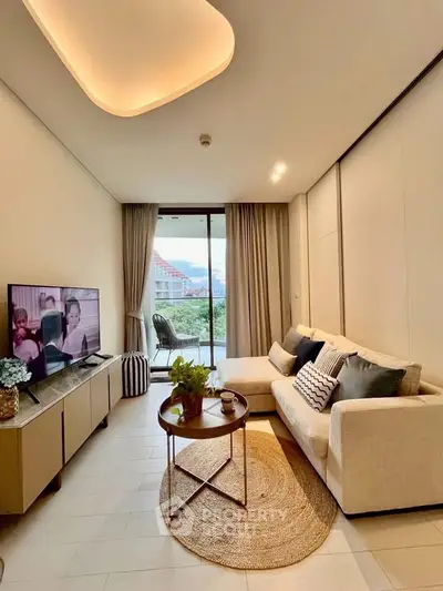 Modern living room with cozy sofa and TV, featuring a balcony view.
