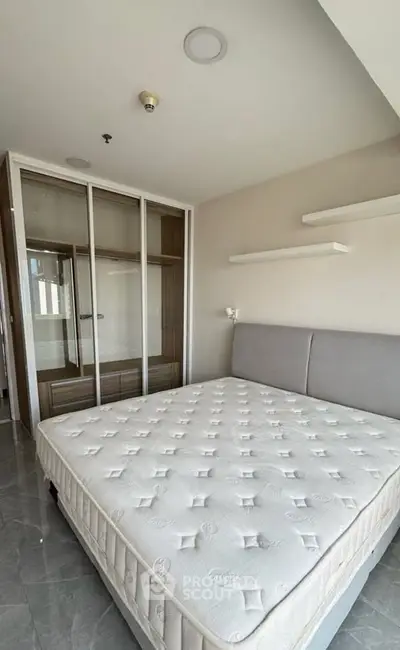 Spacious bedroom with modern design and ample natural light, featuring a comfortable bed and sleek wardrobe.