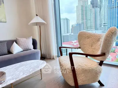 Luxurious living room with plush armchair and city view through large window.