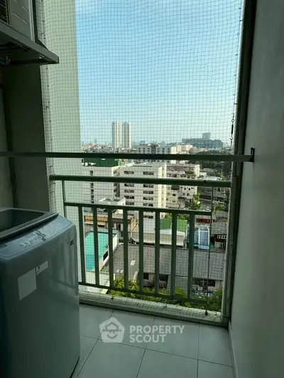 High-rise apartment balcony with city view and washing machine