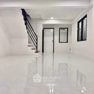 Spacious modern interior with sleek staircase and glossy tiled flooring, perfect for contemporary living.