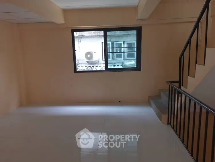 Spacious interior with large window and staircase, ideal for customization.