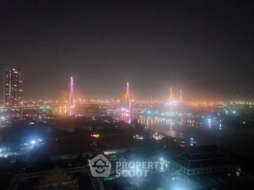 Stunning night view of illuminated cityscape with iconic bridge and skyline reflections.