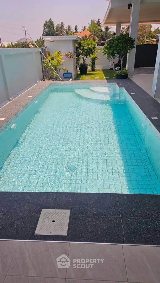 Luxurious private pool with modern design and lush greenery in a serene backyard setting.