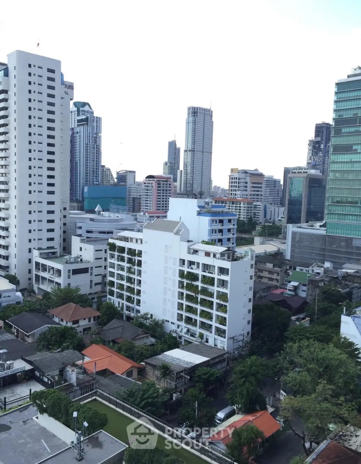 Stunning cityscape view showcasing modern high-rise buildings and lush greenery in an urban setting.