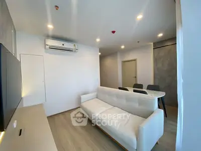 Modern living room with sleek white sofa and dining area in open layout