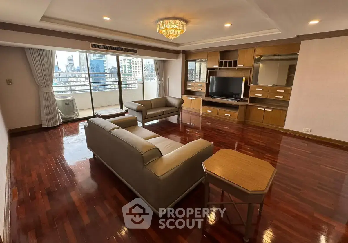 Spacious living room with elegant hardwood floors and city view balcony in luxury apartment.