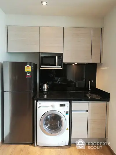 Modern compact kitchen with sleek appliances and wooden cabinetry