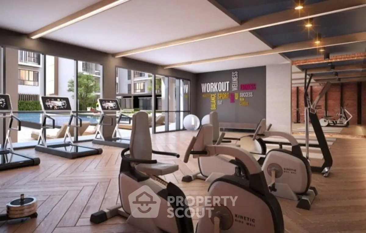 Modern gym with state-of-the-art equipment and large windows in luxury apartment complex.