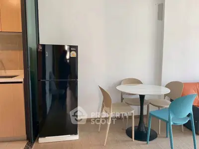 Modern kitchen with sleek black fridge and stylish dining area