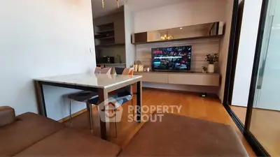 Modern living room with sleek furniture and wall-mounted TV, featuring a cozy dining area and stylish decor.
