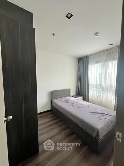 Cozy bedroom with modern decor and large window for natural light