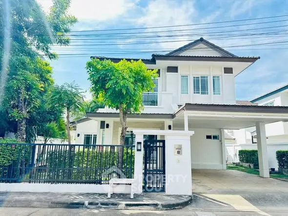 Charming two-story house with spacious driveway and lush greenery in a serene neighborhood.
