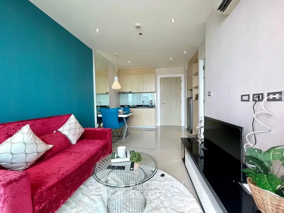 Modern living room with vibrant red sofa and open kitchen layout