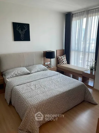 Modern bedroom with stylish decor and natural light, featuring a cozy bed and elegant furnishings.
