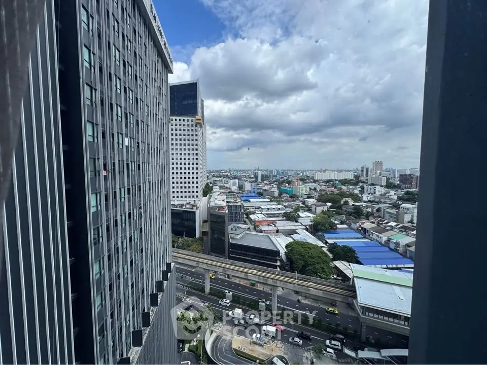 Stunning cityscape view from high-rise building with urban skyline and clear blue sky.
