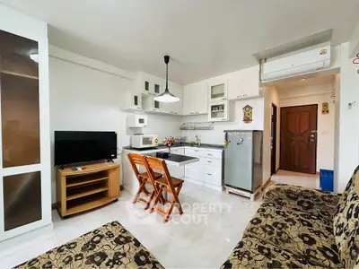 Charming open-layout kitchen and living area with modern appliances and cozy seating in a stylish apartment.