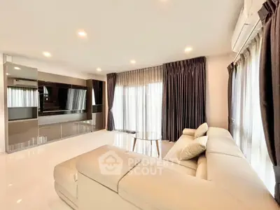 Spacious modern living room with elegant curtains and sleek furniture, perfect for relaxation and entertainment.