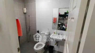 Modern bathroom with shower, toilet, and sink in a sleek design.