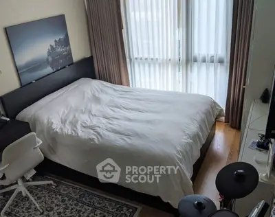 Cozy bedroom with natural light and modern decor, featuring a comfortable bed and stylish furnishings.