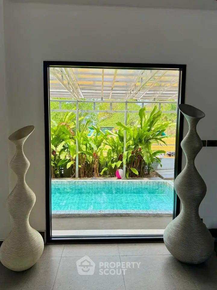 Luxurious poolside view with elegant vases and lush greenery, perfect for relaxation and leisure.