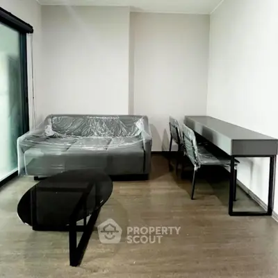 Modern living room with sleek furniture and large window for natural light.