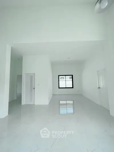 Spacious white interior with high ceilings and marble flooring