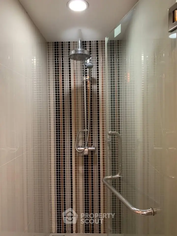 Modern shower with sleek tile design and chrome fixtures in a contemporary bathroom.