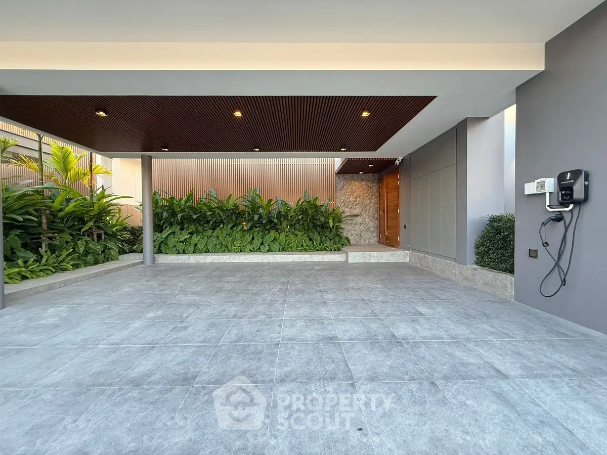 Modern building entrance with sleek design and lush greenery