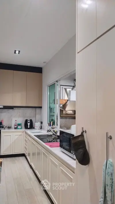 Modern kitchen with sleek cabinetry and built-in appliances, featuring a stylish open layout.
